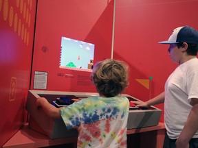 Eli and Sam Nürnberger play Super Mario Bros. with a giant Nintendo controller at the Game Changers exhibition currently on at the Gray Roots Museum and Archives.Greg Cowan/Sun Times