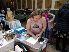 Chelsea Roberts uses an app on her phone to help quickly draw and paint portraits of people's pets at the Mother's Day Handmade Market at Heartwood Hall and Sabitri's Global Cuisine on Sunday, May 14, 2023. Greg Cowan/The Sun Times