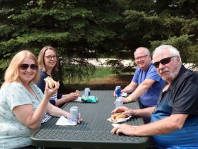 Clockwise from bottom left, Fox Creek evacuees Barb Bakaas, Eva Thesen, Kevin Thesen and Doug McArthur enjoyed the barbecue at Festival Park Friday. The barbecue was co-sponsored by Techmation Electric, Blue Sky Resources and McElhanney for evacuees and supporters.