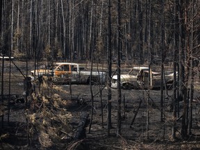 Burnt out trucks from a wildfire sit on a property outside Drayton Valley, Alta. on Wednesday, May 10, 2023. THE CANADIAN PRESS/Jason Franson.