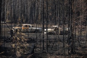 Burnt out trucks from a wildfire sit on a property outside Drayton Valley, Alta. on Wednesday, May 10, 2023. THE CANADIAN PRESS/Jason Franson.
