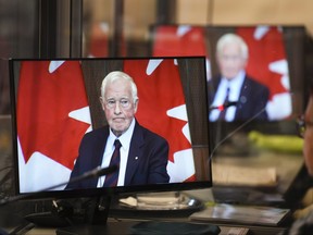 David Johnston, Independent Special Rapporteur on Foreign Interference, is pictured on the screens of translators as he presents his first report in Ottawa on Tuesday, May 23, 2023.