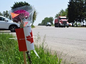 Flowers were laid on Tuesday, May 30, 2023 at the intersection of Oxford County Road 33 and Highway 59, where a collision a day earlier between a school bus and unmarked Ontario Provincial Police vehicle killed both drivers.  (Calvi Leon/The London Free Press)