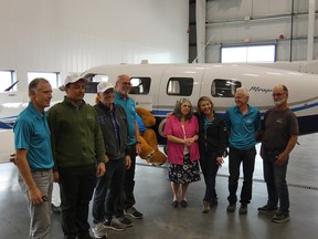 Volunteers with Hope Air gathered at a hangar