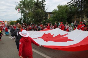 A giant Canadian Flag is carried in the Canada Day Parade in Fort McMurray on July 1, 2022. Vincent McDermott/Fort McMurray Today/Postmedia Network