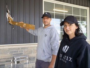 Jay Aristone and his wife Heather Aristone, owners of London Waffle House on Sunset Drive north of Talbotville, show how a two-by-four piece of lumber was driven into the front wall of the restaurant by a tornado that struck Tuesday evening.  Photograph taken on Wednesday, June 14, 2023. (Mike Hensen/The London Free Press)