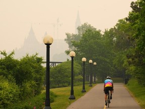 A cyclist rides as smoke from wildfires in Ontario and Quebec obscures Parliament Hill in Ottawa on Tuesday, June 6, 2023. What seems evident is the role that climate change plays in all this. People need to push the people they voted for to make changes.