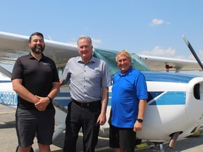 Shawn Broughton, manager of the Brantford Flight Center and Brantford Municipal Airport, joins Brantford Mayor Kevin Davis and Mark Littell, chair of the airport board, near the airport runway.  MICHELLE RUBY/BRANTFORD EXPOSITOR