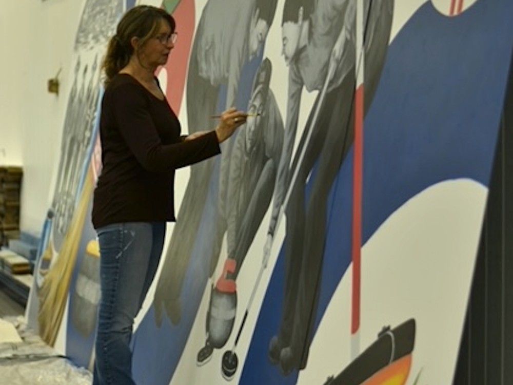 Woman painting on a mural