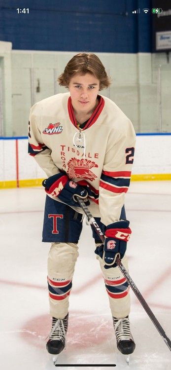 Young hockey player posing on the ice
