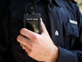 A police body worn camera is held by an officer during an Edmonton Police Service news conference at EPS Headquarters in Edmonton, Alta., on Tuesday June 23, 2015. Police released the results of a three year study to assess the effectiveness of body worn video at the conference.
