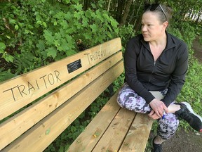 Christine Paterson looks at some of the fresh graffiti on a bench at Lemoine Point Conservation Area in Kingston on Tuesday. Benches and other items in the park have been defaced with politically motivated graffiti.