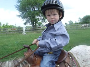 Susanna McLeod's grandson Ryan wears a helmet during horse riding