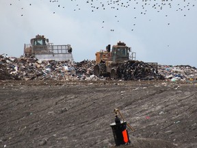 Workers move garbage at the Twin Creeks landfill site near Watford