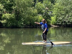 Simcoe Composite School Principal Jennifer Ippolito takes a stand-up paddleboard for a test drive in the Lynn River behind the school on Wednesday afternoon.  The SUP was built by students in the Grade 12 construction class, a project that began in March and was completed on June 16.