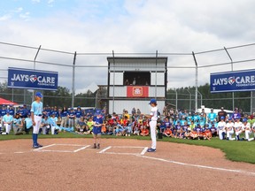 U9A player Taver Rowswell cut the ribbon on the newly improved Jays Care diamond at Graham Acres on Sunday, part of Whitecourt Minor Baseball's Grand Opening and Wind Up event. He was flanked by U15AA player Jacob North, left, and U15A player Cooper Johns-Rowswell.