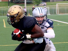 Jacob Bartolucci (6) of the Sudbury Spartans wraps up Richmond Nketiah (85) of the Tri-City Outlaws during Northern Football Conference action at James Jeome Sports Complex in Sudbury, Ontario on Saturday, July 15, 2023.