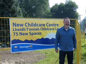 Lheidli T'enneh councillor Kyle McIntosh stands in front of a construction sign reading "New Childcare Centre, Lheidli T'enneh Childcare Centre, 75 new spaces"