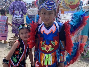 Kiibidigoshin Plain, 2. and his brother Kekwedwe Sands, 5, take a moment before dancing in the tiny tots category at the Six Nations of the Grand River Champion of Champions Pow Wow on Saturday, July 22. They are from the Aamjiwnaang First Nation near Sarnia and were among the hundreds of dancers and drum groups from across North America to participate in the event.