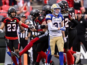 Ottawa Redblacks quarterback Dustin Crum (18) celebrates his touchdown to give the Redblacks a chance to tie the game, as Winnipeg Blue Bombers defensive back Evan Holm (31) walks past, during second half CFL football action in Ottawa on Saturday, July 15, 2023.