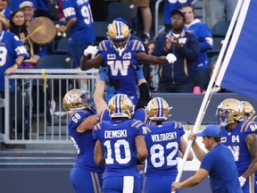 Greg McCrae (29) of the Winnipeg Blue Bombers is lifted up by his teammates after scoring on a 68-yard passing play during a 24-11 win over the Calgary Stampeders on Friday night at IG Field.