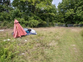 A collapsed tent and and patio umbrella are shown on the site of a homeless encampment that was dismantled one day prior in St. Thomas.  Photo taken on Thursday July 20, 2023. (Derek Ruttan/The London Free Press)