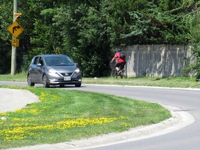 A cyclist rides along the sidewalk on a portion of Bayridge Drive where construction of new cycling infrastructure is to begin this month in Kingston
