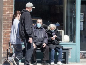 People wearing masks practice social distancing during the COVID-19 pandemic on April 2, 2020.