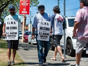 Striking port workers belonging to the International Longshore and Warehouse Union Canada walk the picket line near the Port of Vancouver’s Clark Dr. entrance in Vancouver, B.C., on July 1, 2023.