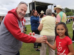 Mayor Tom Pickard handed out free cupcakes to attendees of Whitecourt's Canada Day celebration, including to Ysabel Palisoc.