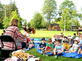 Stratford Public Library children's librarian Trish MacGregor leads Sunshine Story Time for nearly 50 kids 6 and under at Anne Hathaway Park in Stratford Tuesday morning.