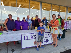 Kicking off the holiday weekend the Espanola Elks had a barbeque set up for the public in front of TannerÕs YIG on Thursday, Friday and Saturday. Despite heavy rains and even hail throughout the day on Thursday, the Elks stood fast. (L-R) Angela Houle, Beth McVey, Sheri Commission, George Commission, Barb Reynolds, Chuck Trahan, Doug Reynolds along with three happy customers. Photo by Patricia Drohan