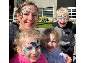 A woman with three children, all with painted faces.