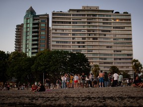 People dance and gather at English Bay Beach during a heat wave, in Vancouver, B.C., on Monday, June 21, 2021.