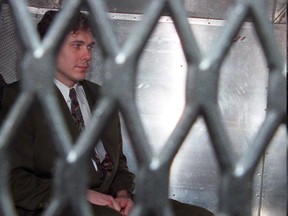 Paul Bernardo arrives at the provincial courthouse in the back of a police van in Toronto in a November 3, 1995 file photo