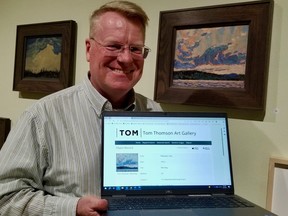 David Huff displays the online entry for "Morning,"the painting beside him at the Tom Thomson Art Gallery. The gallery's Thomson collection of art and related items is now available to be viewed on the gallery's website. (Scott Dunn/The Sun Times/Postmedia Network)