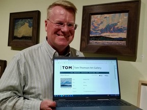 David Huff displays the online entry for "Morning,"the painting beside him at the Tom Thomson Art Gallery. The gallery's Thomson collection of art and related items is now available to be viewed on the gallery's website. (Scott Dunn/The Sun Times/Postmedia Network)