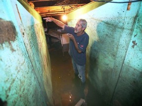 Eddie Pereira points to the level of water that flooded his basement on Erie Street North in Harrow on Thursday, August 24, 2023. (Dan Janisse/Windsor Star)
