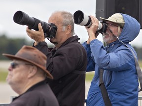 Photographers train their telephoto lenses on planes