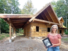 Diane Bergsma holds a photograph of her son Dalles in front of the Three Oaks Respite Cabin under construction. Her son, who was a farmer and volunteer firefighter, took his life in November 2020 at age 27. The Bergsma family is building this retreat to provide free help to farmers and first-responders who are suffering with stress and anxiety. PHOTO Ellwood Shreve/Postmedia