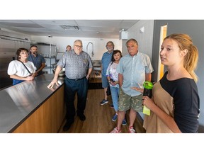 Jessica Mostert-Thiessen, program manager for Indwell's new affordable housing building at 16 Queen St. in St. Thomas, talks to Mayor Joe Preston and Coun.  Steve Peters inside the complex on Thursday Aug.  17, 2023. (Mike Hensen/The London Free Press)