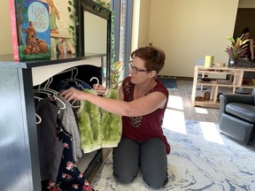 Unity Child Care Centre director Krystal Oxbro hangs dress-up clothes in the new location on Cataraqui Woods Drive location in Kingston, Ont. on Friday, Aug. 18, 2023 Elliot Ferguson/The Whig-Standard/Postmedia Network
