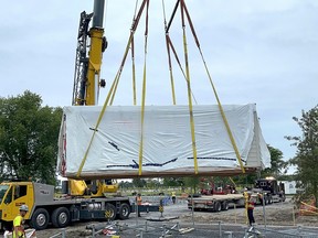 A crane lifts a modular home into its final resting spot