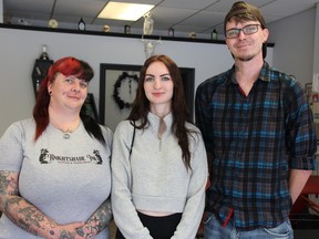 Madison Holley, middle, poses with Knightshade Ink's Mel and Shawn Knight at the Sarnia tattoo shop.