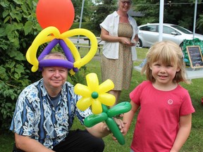 Andy the Balloon Guy hands one of his creations to six-year-old Brooklyn Brady at the Simcoe Heritage Friendship Festival on Sunday.  Held in Wellington, Clifton and Grant Anderson parks over the long weekend, the event attracted thousands of visitors.  MICHELLE RUBY/SIMCOE REFORMER