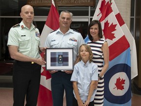 Chief of Defence Staff General W. D. Eyre congratulates Simcoe native Ryan Deming on his promotion to the rank of Brigadier General. Deming is with his wife Monica and son Luke.