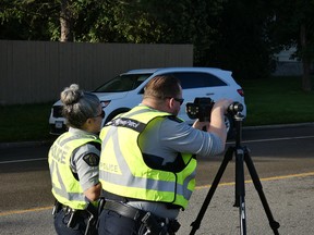 Two police officers looking through a speed radar.