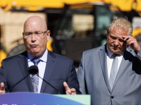 Ontario Premier Doug Ford listens as Ontario Minister of Housing Steve Clark speaks at a news conference in Mississauga on Friday, Aug. 11, 2023.