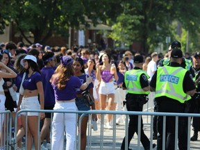 Crowds gather on Broughdale Avenue in London to celebrate Western University's homecoming on Saturday, Sept. 23, 2023. Police maintained a large presence in the area and closed Broughdale and nearby streets to vehicles.  (Dale Carruthers/The London Free Press)