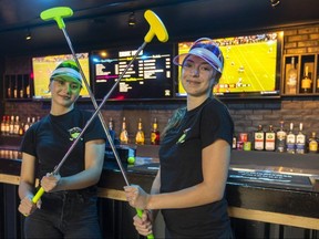 Brooklynn Gillmore, left, and Evelina Hranovska, both bartenders at Par-Tee-Putt at 545 Richmond St. in London, get ready to play on Friday, Sept. 1, 2023. (Mike Hensen/The London Free Press)